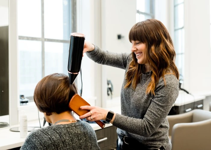 A hairdresser styling a client